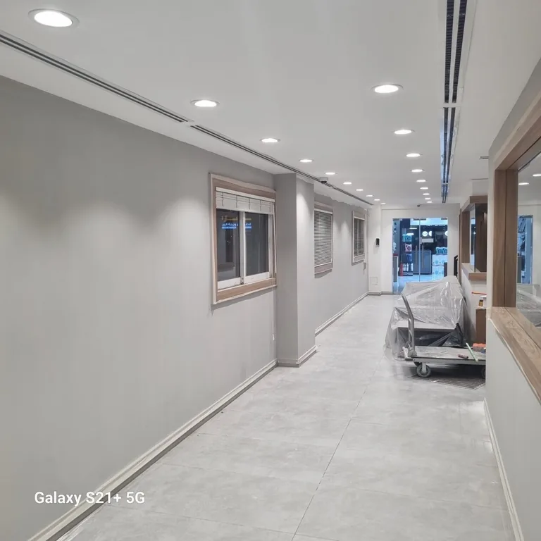 Office corridor with freshly painted grey walls and protected furniture on a trolley