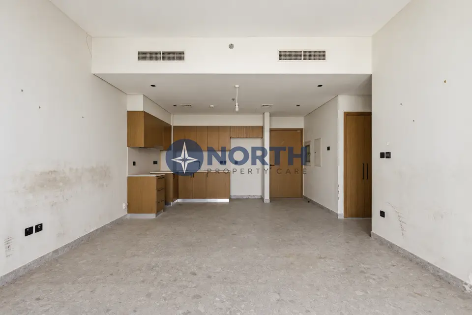 Golf Suites living area and open kitchen walls with stains and marks before repainting