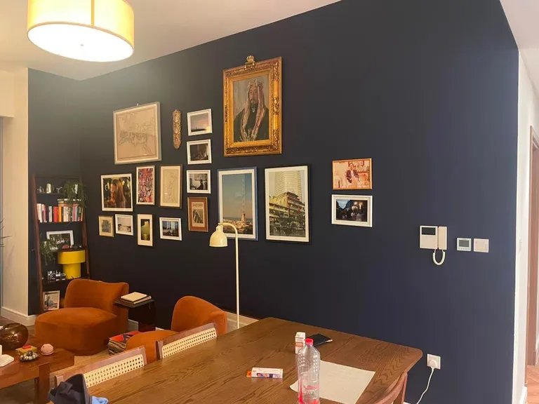 Blue wall with framed pictures hanging before move-out painting at Canal Front Building, Business Bay