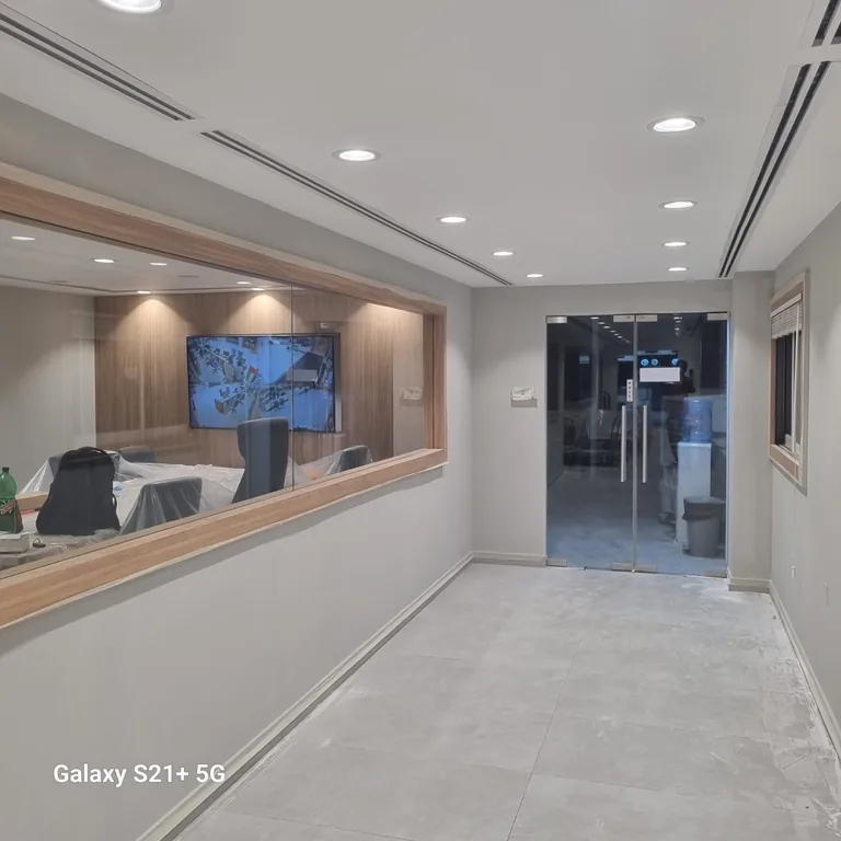 Office corridor with grey painted walls and the glass entrance in the DIFC office