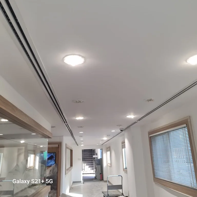 White office corridor prepared for painting with a ladder in place in DIFC