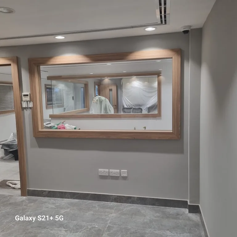 Grey painted office wall with a wood-framed glass partition