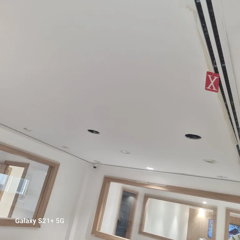 Office ceiling edges masked with tape before wall painting in the DIFC office