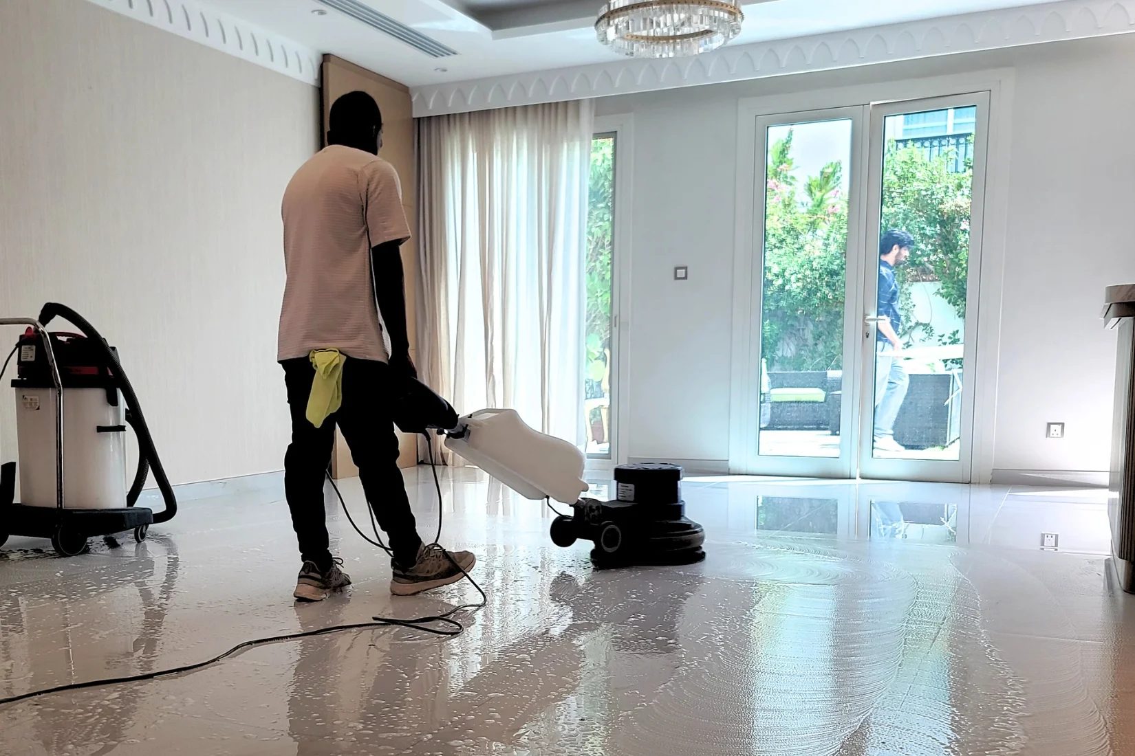 Floor being machine scrubbed during a deep clean in a Dubai home