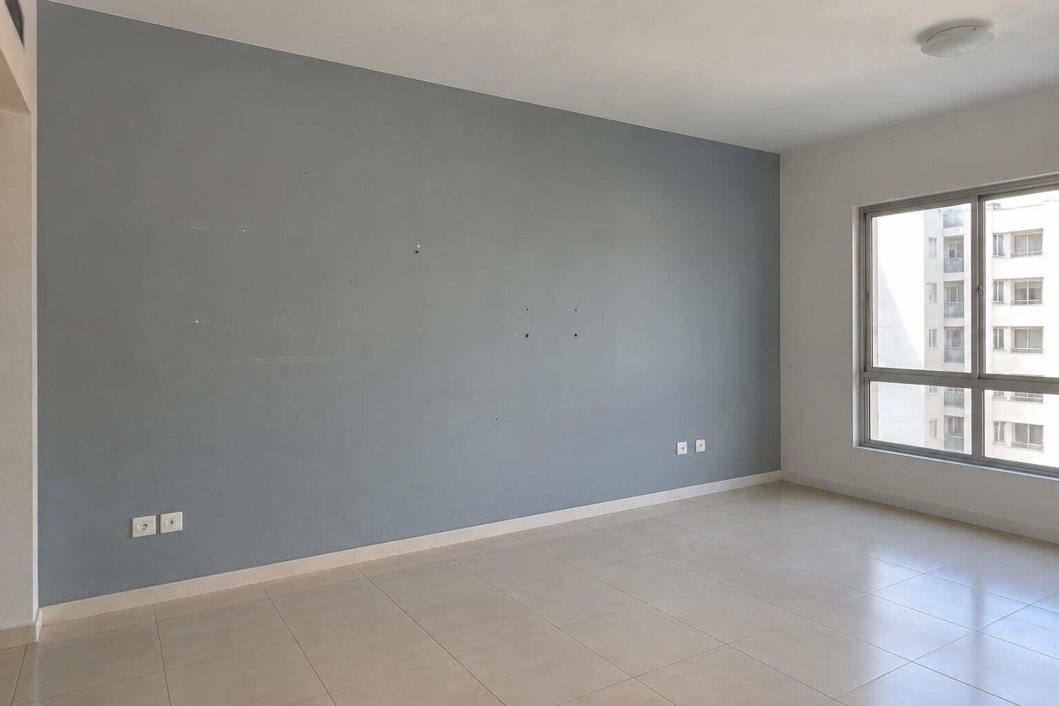 Interior room with a marked grey-blue wall before preparation and repainting